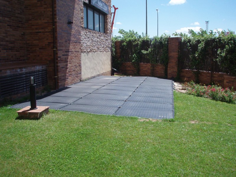 Paneles OKU instalados en jardín — superficie horizontal sobre césped