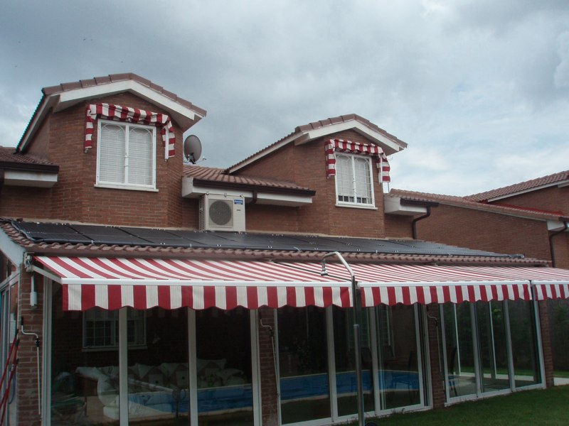 Chalet con toldo y piscina cubierta — paneles OKU en tejado bajo