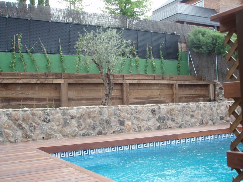 Piscina con paneles OKU en muro de jardín — instalación vertical